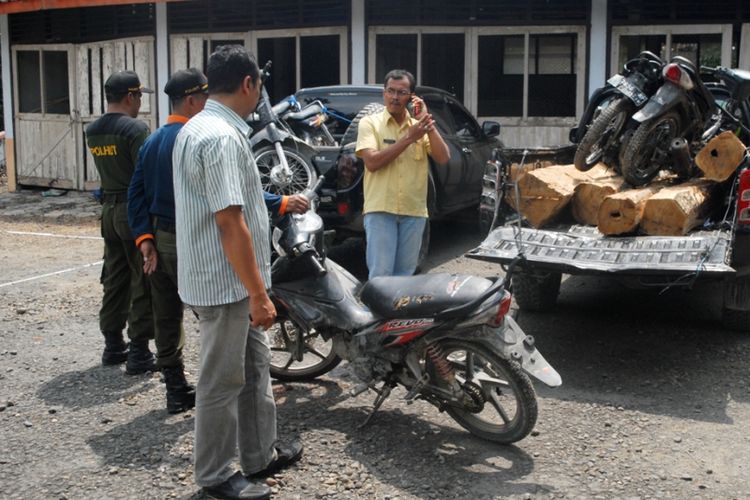 Petugas Perhutani KPH Gundih, Kabupaten Grobogan, Jawa Tengah, menunjukkan barang bukti motor dan kayu jati hasil illegal logging yang berhasil diungkap, Rabu (25/4/2018).