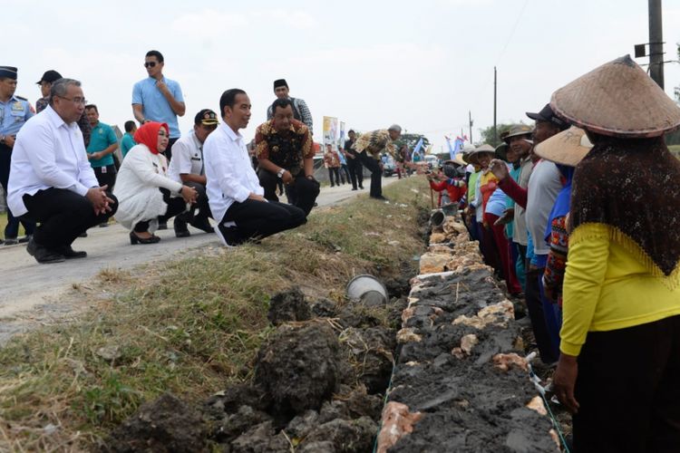 Presiden Joko Widodo (Jokowi) didampingi Menteri Desa, Pembangunan Daerah Tertinggal, dan Transmigrasi (Mendes PDTT) Eko Putro Sandjojo meninjau program Padat Karya Tunai (PKT) pembangunan talud jalan di Desa Tambirejo, Kecamatan Toroh, Kabupaten Grobogan, Jawa Tengah, Sabtu (15/9/2018)