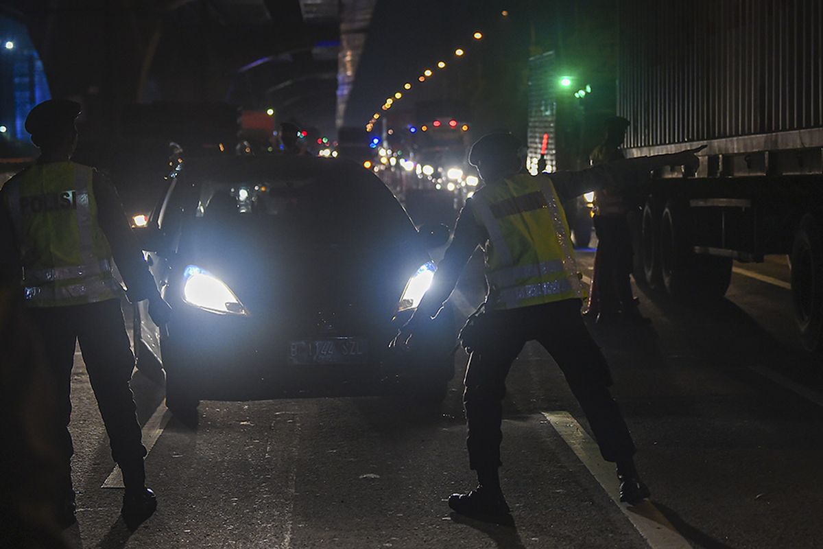 Petugas kepolisian mengarahkan kendaraan pribadi yang melintas di tol Jakarta-Cikampek untuk keluar melalui pintu tol Cikarang Barat 3, Jawa Barat, Kamis (21/5/2020). Pengalihan tersebut sebagai upaya penyekatan gelombang pemudik jelang perayaan Hari Raya Idul Fitri 1441 H dari arah Jakarta menuju Jawa Tengah.