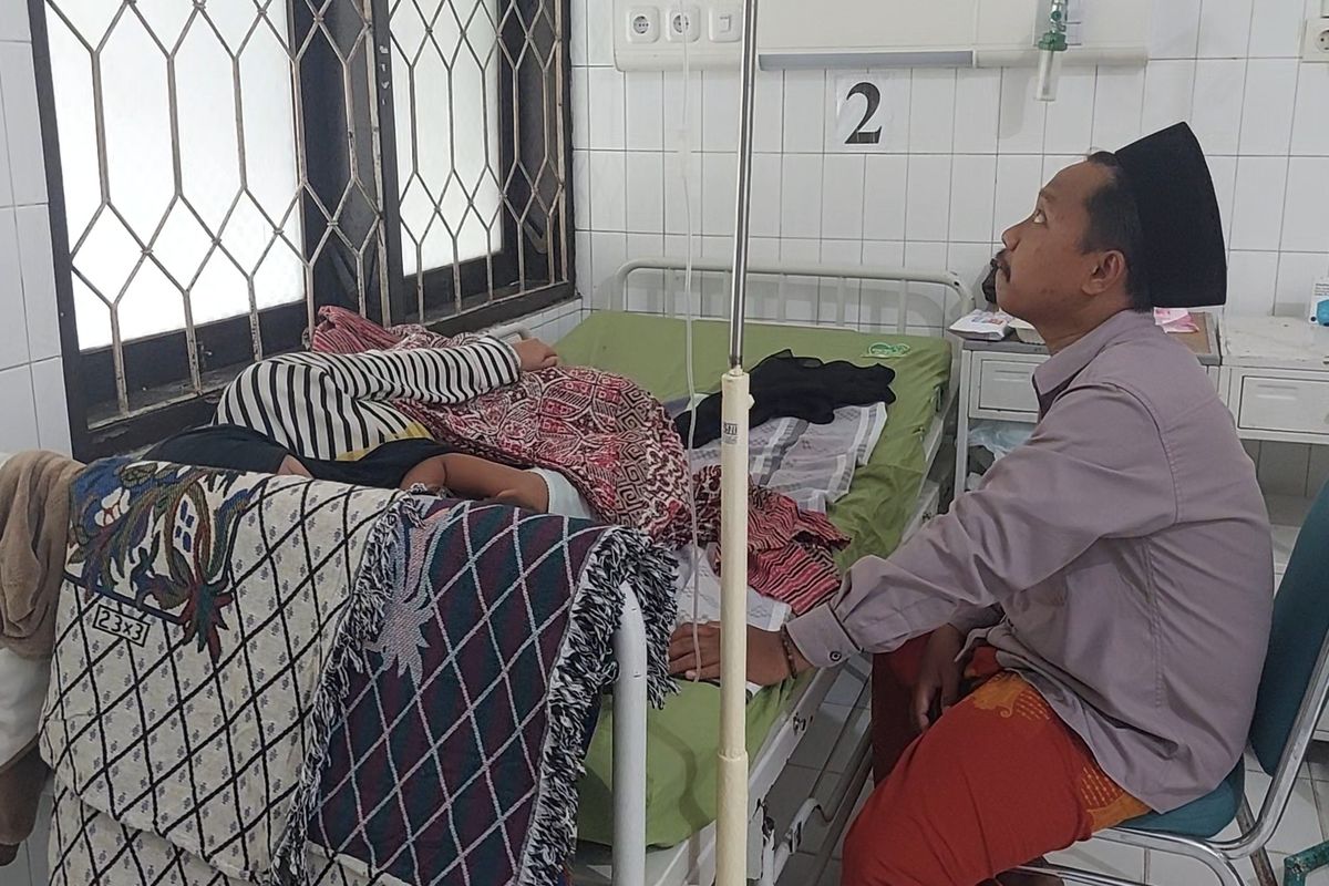 Seorang anak penderita campak saat ditemani oleh ibu dan bapaknya di RSUD dr. H. Moh. Anwar Sumenep, Jawa Timur.. 