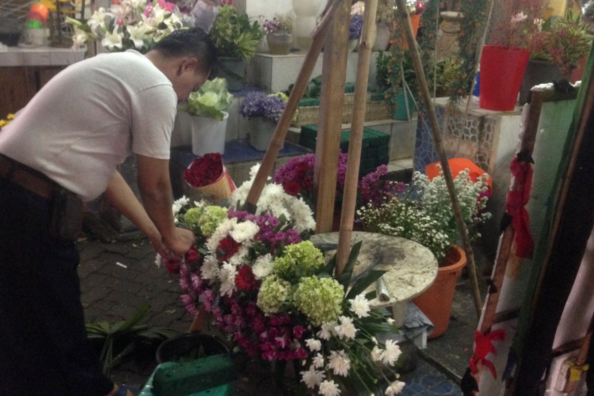 Umar (40) salah satu penjual bunga di Pasar Kembang Cikini, Jakarta Pusat, sedang merangkai bunga papan yang ditujukan ke Balai Kota, Rabu (26/4/2017).
