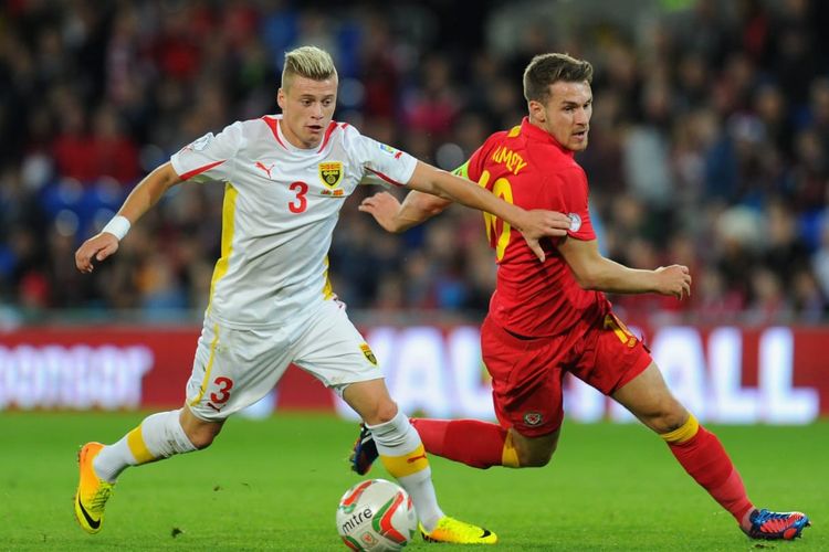 Pemain Makedonia Utara, Ezgjan Alioski (kiri), berduel dengan kapten Wales, Aaron Ramsey (kanan), pada 13 Oktober 2013.