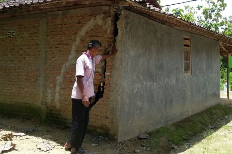 Warga Desa Dayakan, Kecamatan Badegan, Kabupaten Ponorogo menunjukkan dinding rumahnya yang retak karena terdampak tanah gerak.