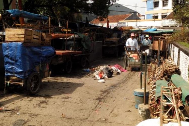 Sejumlah warga saat melintasi tumpukan roda berjualan para pedagang Pasar Andir di Jalan Rajawali Kota Bandung, Jumat (5/2/2016). Para pedagang terpaksa berjualan di jalan lantaran belum adanya tempat yang layak.