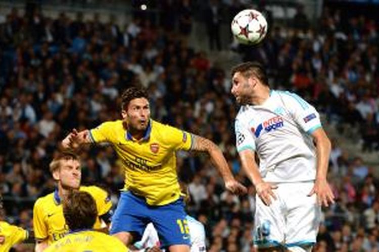 Penyerang Arsenal Olivier Giroud (kedua dari kanan) berebut bola dengan penyerang Marseille Andre-Pierre Gignac, pada pertandingan fase grup Liga Champions, di Stade Velodrome, Marseille, Rabu (18/9/2013).