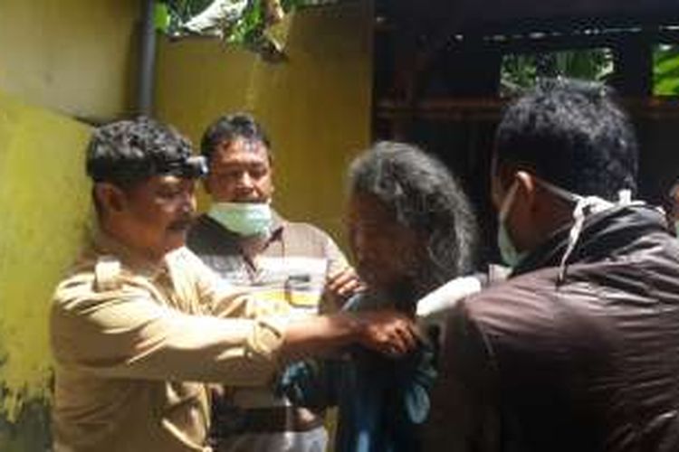 Supariyadi (tengah) penderita gangguan jiwa saat mau dimandikan oleh petugas usai dikeluarkan dari ruangan yang membekapnya, Senin (31/10/2016)