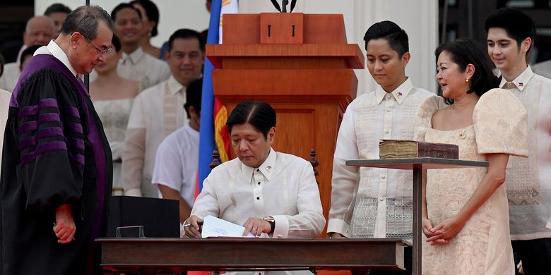 Members of his family (right) look on as new Philippine President Ferdinand Marcos Jr. (seated center) is sworn in as the country's new leader, during his inauguration ceremony at the National Museum in Manila on June 30, 2022. (Photo by JAM STA ROSA / AFP)