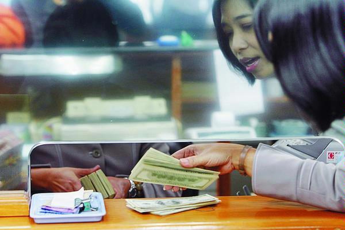 Staf perusahaan penukaran uang di kawasan Kwitang, Jakarta, menghitung lembaran dollar AS.