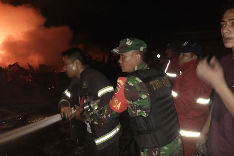 Petugas TNI dan damkar berupaya memadamkan api kebakaran ruko dan kios di Pasar SP 1 Desa Kijang Kaya, Kecamatan Tapung Hilir, Kabupaten Kampar, Riau, Selasa (9/3/2021) malam.