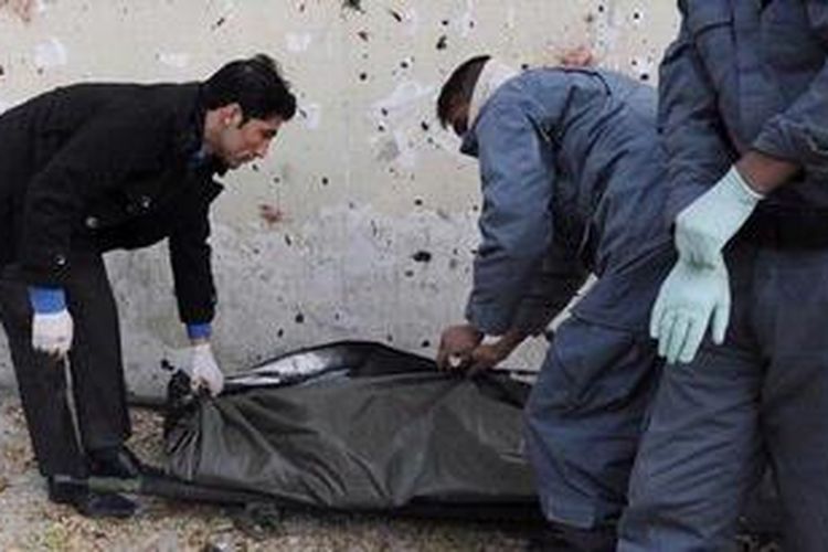 Polisi Afganistan membungkus jenazah korban bom bunuh diri di distrik diplomatik Kabul, Rabu (21/11/2012).