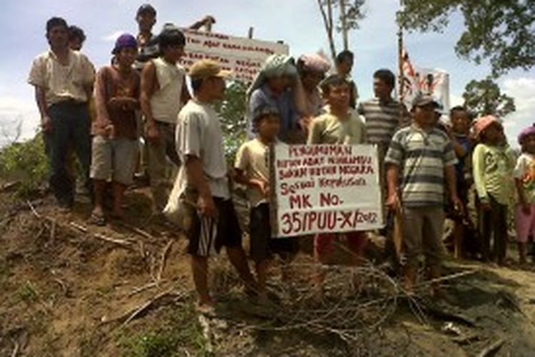 Puluhan warga memasang plakat pengumuman hutan adat di lahan yang diklaim PT TPL sebagai bagian ijin konsesi mereka, di Dusun Naga Hulambu, Nagori Pondok Buluh, Kecamatan Dolok Panribuan, Kabupaten Simalungun, Sumatera Utara, Sabtu (22/6/2013).