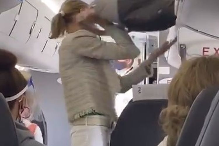 Tangkapan layar seorang penumpang perempuan American Airlines yang dipaksa keluar dari pesawat karena tidak memaki masker.