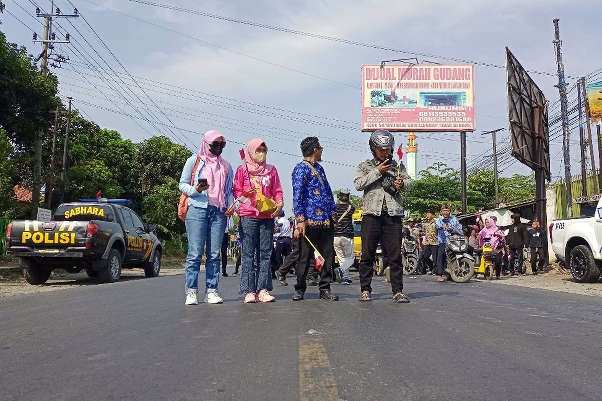 Anita (paling kiri) dan ratusan pengendara berhenti sejenak mengheningkan cipta mengenang jasa para pahlawan di Jalur Pantura Kecamatan Pajarakan, Kabupaten Probolinggo, Jawa Timur, Jumat (10/11/2023). 