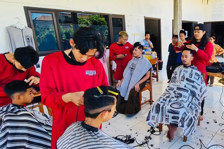 Sekelompok tukang cukur yang tergabung dalam Jumat Ganteng sedang mencukur rambut anak-anak di pesantren di Malang Raya secara gratis sebagai bentuk sedekah.