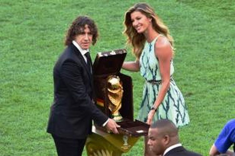 Carles Puyol dan Gisele Bundchen memamerkan trofi Piala Dunia 2014 jelang laga final Argentina vs Jerman di Stadion Maracana, Rio de Janeiro, Minggu (13/7/2014) atau Senin dini hari WIB.