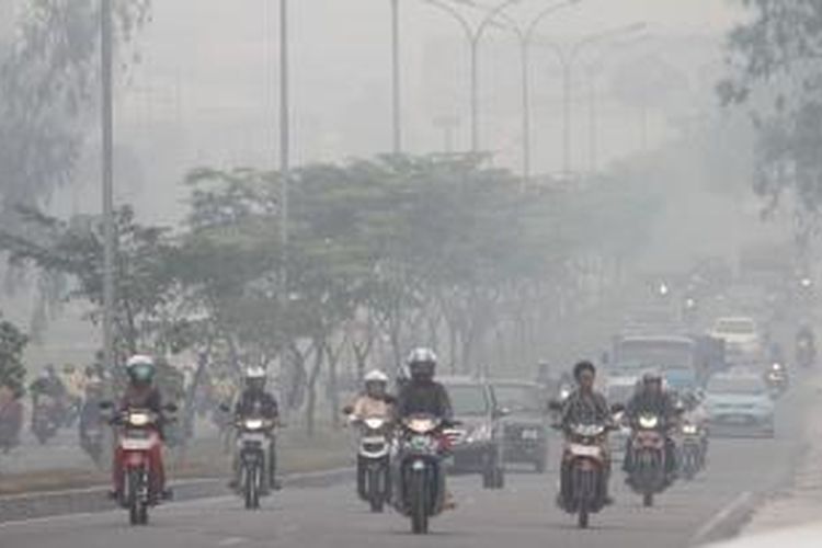 Kabut asap yang menyelimuti Kota Pekanbaru semakin pekat, Selasa (18/2/2014). Pada hari ini, jumlah titik api di Riau yang berhasil dideteksi satelit Terra dan Aqua mencapai 241 titik api. 