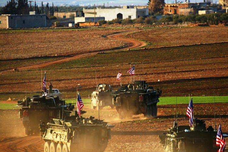 Konvoi kendaraan lapis baja AS bergerak mendekati sebuah desa tak jauh dari kota Manbij, Suriah.