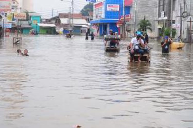 Anak-anak terlihat bermain di jalan yang terendam banjir di Bandung selatan, Kamis (25/12/2014). Intensitas hujan yang cukup tinggi membuat banjir tak juga surut, bahkan cenderung meluas dan naik berkisar antara 50 cm-3 meter.