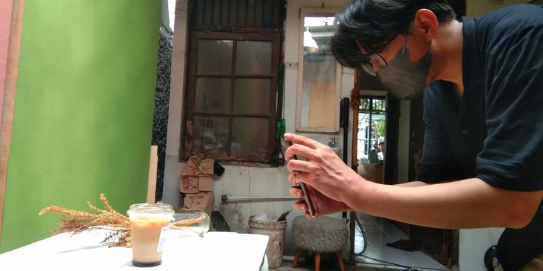 Indra Rismayadi, salah satu founder Smntara Coffee tengah memfoto kopi susu kambing buatan Smntara Coffee, Selasa (21/9/2021).