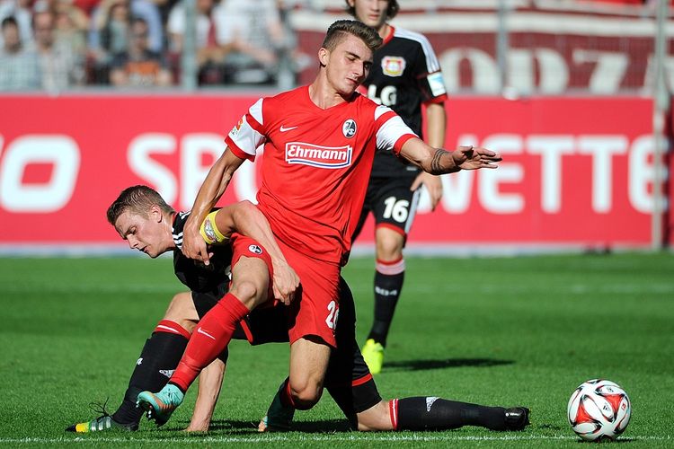 Gelandang Freiburg, Maximilian Philipp (C), bersaing dengan gelandang Leverkusen, Lars Bender (kiri) selama pertandingan sepakbola Bundesliga divisi satu Jerman, SC Freiburg vs Bayer 04 Leverkusen di Freiburg, Jerman barat daya pada 27 September 2014.