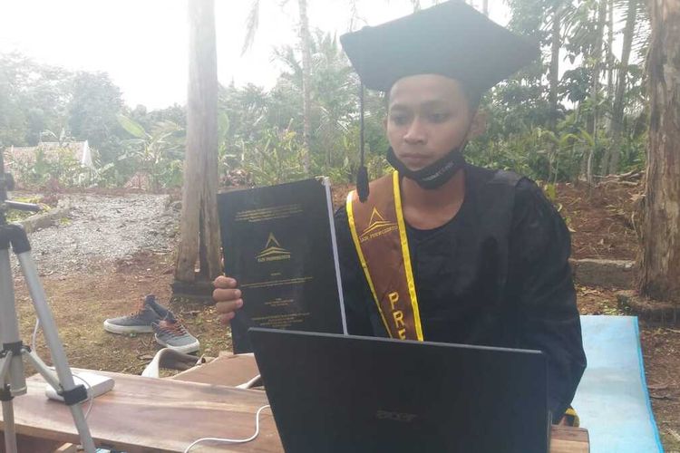 Mochamad Nadif Nasrulloh (23), mahasiswa IAIN Purwokerto mengikuti prosesi wisuda virtual di makam ayahnya di Kabupaten Banjarnegara, Jawa Tengah, Selasa (24/11/2020).