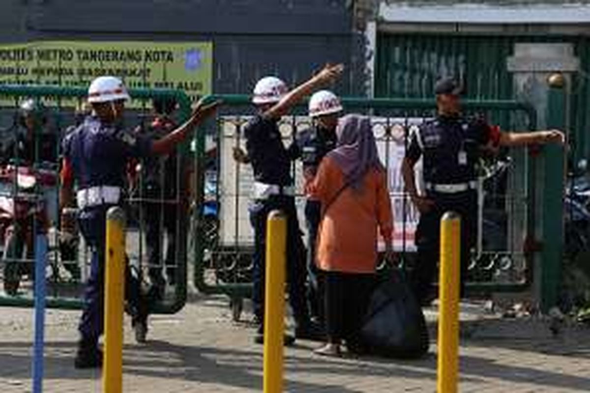 Salah seorang calon penumpang kereta api diarahkan petugas menuju pintu timur Stasiun Tangerang, Banten, Kamis (21/7/2016). Akses pintu barat menuju Stasiun Tangerang ditutup oleh kepolisian dan pemerintah kota setempat karena diduga menyebabkan kemacetan.