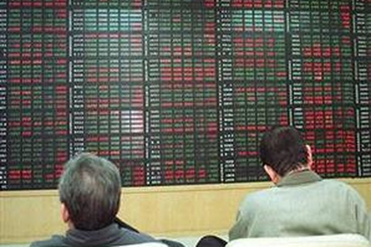 Investor Korea Selatan duduk di depan papan elektronik yang menunjukkan pergerakan nilai saham.