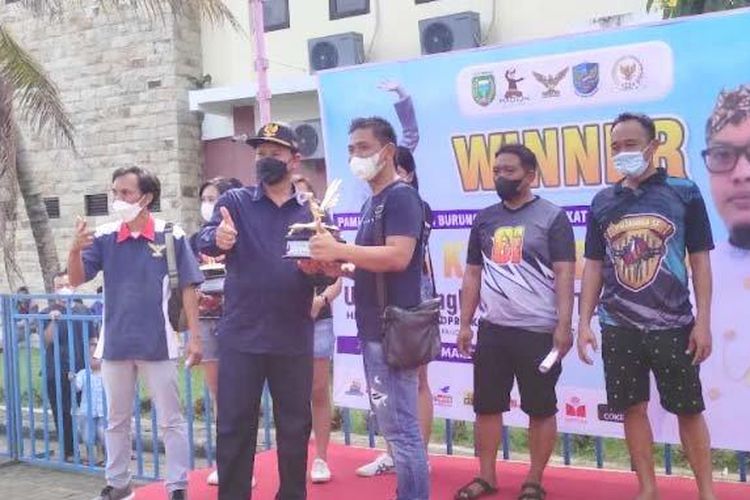 Wali Kota Madiun, Maidi menyerahkan trofi juara Lomba Kicau Burung Piala Ketua DPRD Kota Madiun kepada Andri Bolang, Minggu (6/3/2022). (Sofyan Arif)