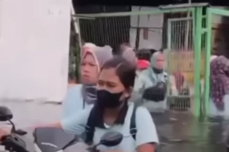 Karyawati terpaksa mendorong sepeda motornya karena rob di Pelabuhan Tanjung Emas Semarang. Senin (23/5/2022)