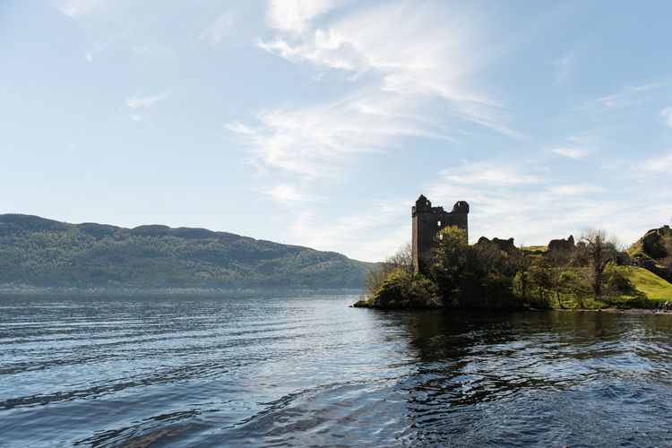 Ilustrasi Kastel Urquhart yang berdampingan dengan danau Loch Ness di Skotlandia.