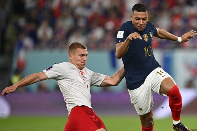 Kylian Mbappe berduel dengan Rasmus Kristensen dalam laga Grup D Piala Dunia 2022 Perancis vs Denmark di Stadion 974, Doha, Qatar, 26 November 2022.