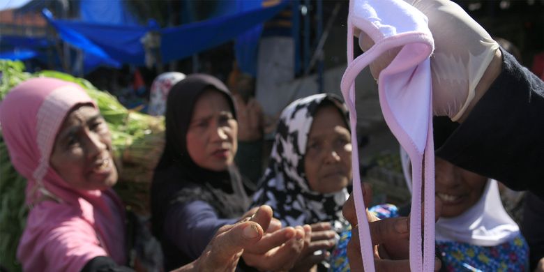 Komunitas etnis tionghoa yang tergabung dalam Yayasan Hakka Aceh membagikan masker dan hand sanitizer kepada pedagang kaki lima dan warga di pasar Peunayong,Kota Banda Aceh. Rabu (08/04/2020). 5000 masker dan hand sanitizer ini dibagikan secara geratif kepada pedagang kaki lima dan warga yang tidak memilki masker saat beraktifitas diluar rumah ini dilakukan sebagi aksi berbagi sesama untuk mencegah penyebaran wabah virus corona di Aceh, seperti himbauan pemerintah masyarakat wajib menggunkan masker saat melakukan aktivitas di luar rumah.