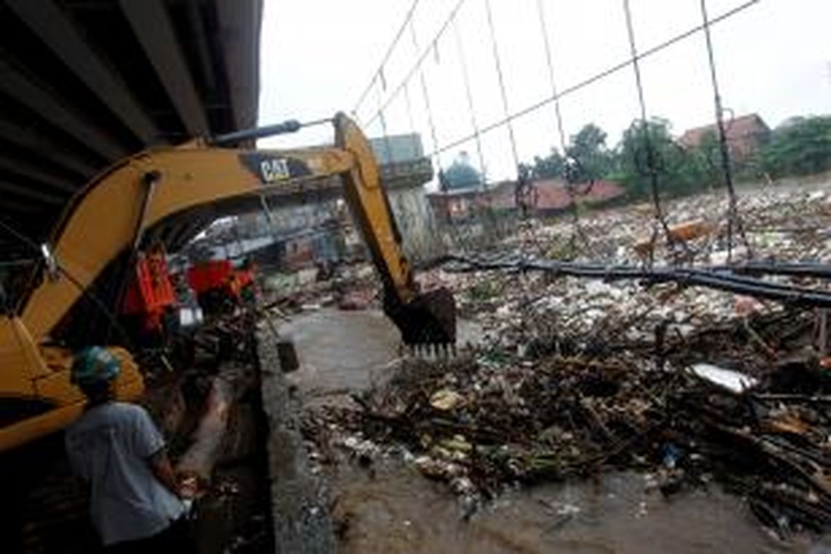 Petugas melakukan pengerukan sampah di aliran Sungai Ciliwung di bawah Jembatan Kalibata, Jakarta Selatan, Selasa (21/1/2014). Selain faktor curah hujan dan buruknya drainase, kebiasaan masyarakat membuang sampah di sungai turut menjadi salah satu penyebab banjir. KOMPAS IMAGES/KRISTIANTO PURNOMO