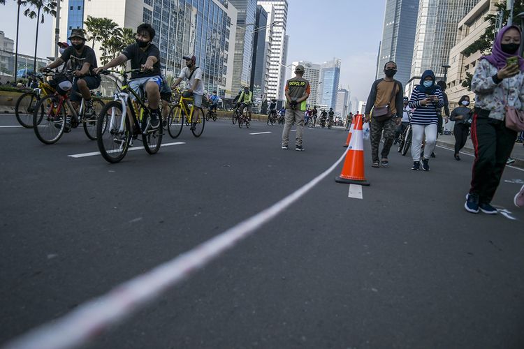 Warga berolahraga saat hari bebas berkendara atau car free day (CFD) di kawasan Jalan MH Thamrin, Jakarta, Minggu (21/6/2020). Dinas Perhubungan (Dishub) Provinsi DKI Jakarta memisahkan jalur untuk pesepeda, olahraga lari, dan jalan kaki saat CFD pertama pada masa pembatasan sosial berskala besar (PSBB) transisi.