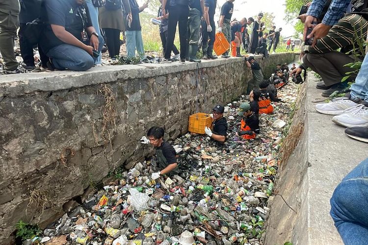 Pandawara Group beserta sejumlah volunter nya saat tengah membersihkan sampah di selokan kecil di Taman Kota Baleendah, Kelurahan Baleendah, Kabupaten Bandung, Jawa Barat pada Jumat (10/11/2023)