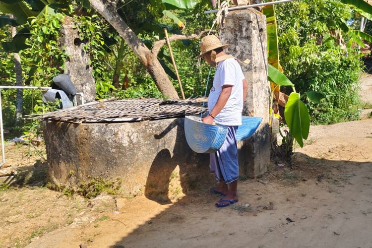 Warga desa Prancak saat akan menimba air di sumur yang ditutup dengan saksak tembakau. 