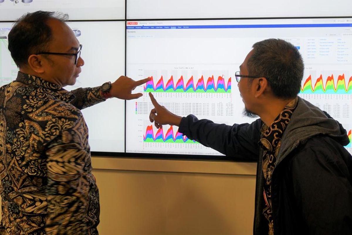 Chief Teknologi Officer XL Axiata, I Gede Darmayusa (kiri) bersama dengan Head Customer Experience & Service Operation XL Axiata, Ilham Yuniawan (kanan) memantau pergerakan trafik di ruang monitoring Customer Experience and Service Operation Center ( CESOC ) yang ada di kantor pusat XL Axiata, Senin (16/3). 