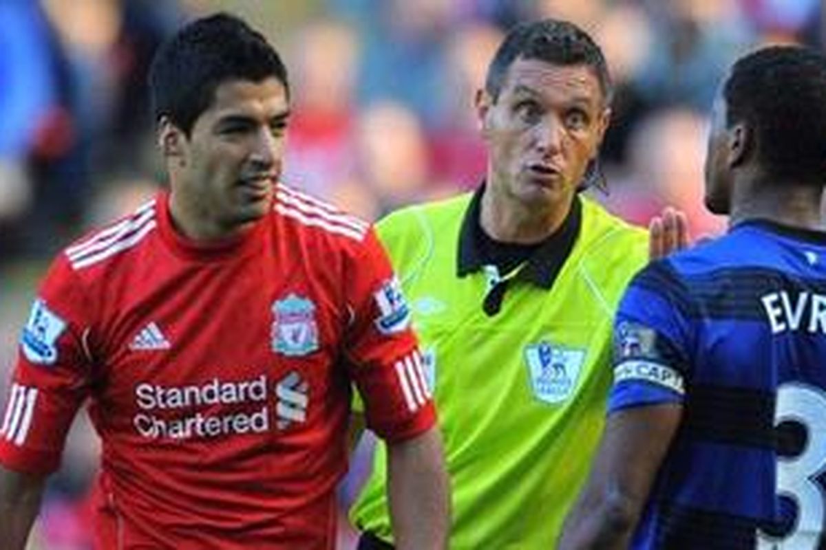 Striker Liverpool, Luis Suarez, tampak cekcok dengan defender Manchester United, Patrice Evra, pada pertandingan Premier League, Sabtu (15/10/2011). Sementara wasit Andre Marriner mencoba melerai. Evra menuduh Suarez kerap melontarkan kata-kata rasial kepadanya.