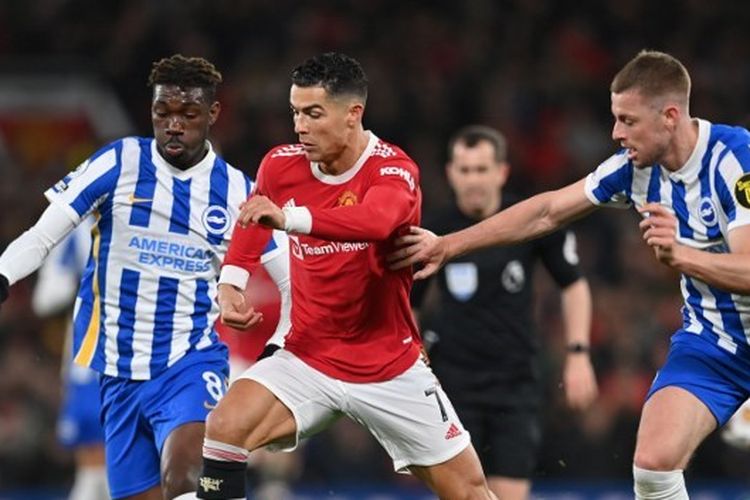 Cristiano Ronaldo (tengah) berduel dengan Yves Bissouma (kiri) dan Adam Webster dalam laga Man United vs Brighton. Laga yang digelar di Stadion Old Trafford, Manchester, tersebut merupakan partai tunda pekan ke-18 Liga Inggris 2021-2022.