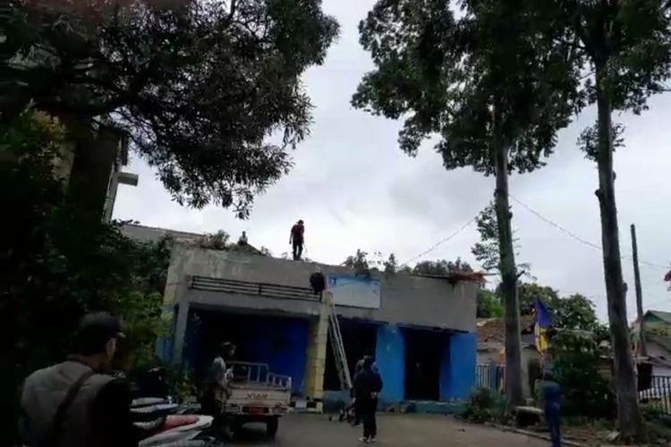 Sebuah pohon  di Kantor Kelurahan Uwung Jaya, Kecamatan Cibodas, Kota Tangerang tumbang dan menimpa rumah warga hari ini Kamis (9/2/2023). Pohon itu tumbang akibat hujan disertai angin kencang yang melanda sejumlah wilayah Kota Tangerang sejak pagi tadi.