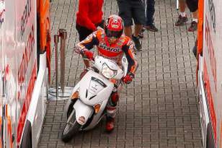 Pebalap Repsol Honda asal Spanyol, Marc Marquez, tiba di area paddock dengan skuter setelah terjatuh saat menjalani sesi kualifikasi GP Belanda di Sirkuit Assen, Sabtu (25/6/2016).