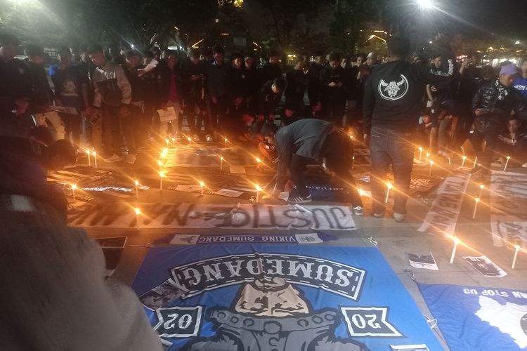 Ratusan kelompok suporter Persib Bandung asal Sumedang menggelar doa bersama untuk korban tragedi Kanjuruhan, Malang, di Alun-alun Sumedang, Jabar, Kamis (6/10/2022) malam. AAM AMINULLAH/KOMPAS.com