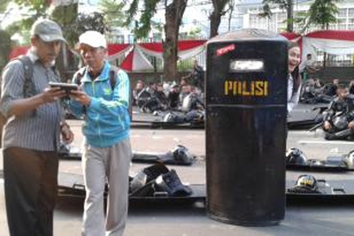 Beberapa karyawan dari gedung Kementerian Agama keluar untuk berfoto dengan polisi yang berjaga di jalan. Menurut mereka, aksi unjuk rasa pendukung Prabowo-Hatta tidak terlalu serius sehingga mereka bisa mengabadikan momen ini dengan berfoto narsis, Kamis (21/8/2014) sore.