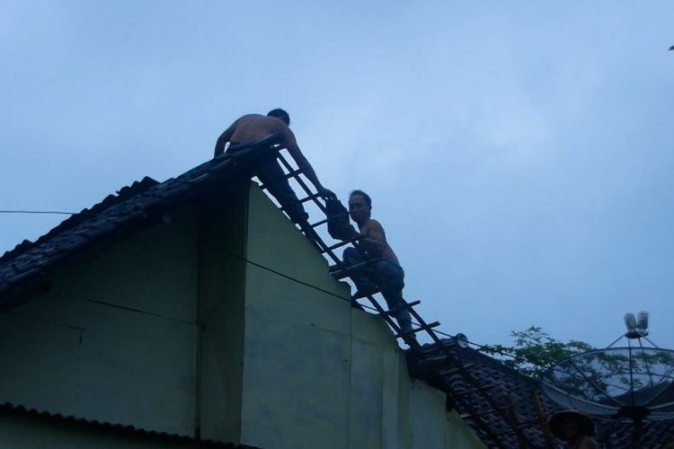 Warga mulai memperbaiki atap rumah yang tersapu angin puting beliung, Jumat (27/1/2023)