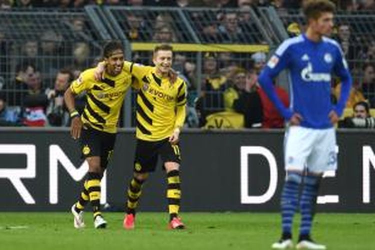 Penyerang Borussia Dortmund, Marco Reus (2 dari kiri) dan rekannya, Pierre-Emerick Aubameyang (kiri), merayakan gol yang dicetak ke gawang Schalke dalam laga Bundesliga di Signal Iduna Park, Sabtu (28/2/2015).