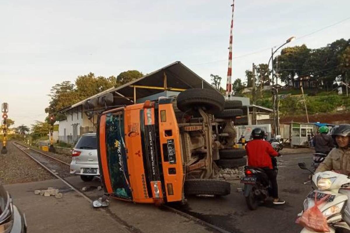 Sebuah truk terguling di perlintasan rel kereta api Batu Tulis, Kota Bogor, Jawa Barat, Sabtu (14/1/2023).