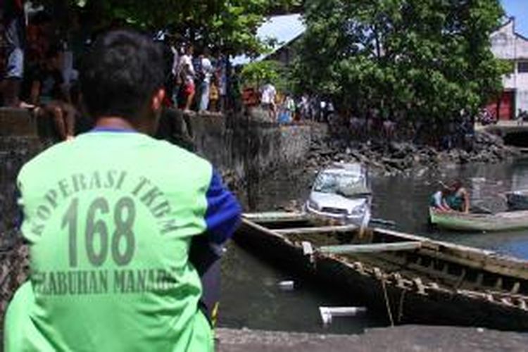 Sebuah mobil Toyota Rush menjadi tontonan warga setelah terjun ke laut di Pelabuhan Manado.