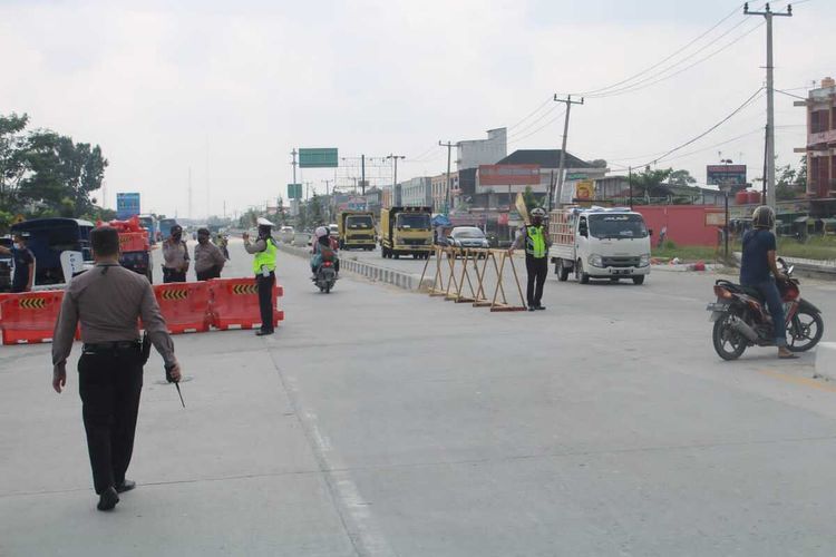 Anggota Polresta Pekanbaru melakukan penyekatan dalam masa PPKM Level 4, di jalan lintas Riau-Sumbar, Jalan HR Soebrantas, salah satu akses keluar masuk Kota Pekanbaru, Riau, Senin (26/7/2021).