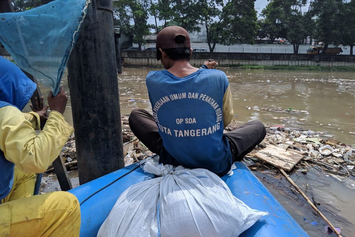 Para petugas kebersihan Cisadane dari Dinas PUPR Kota Tangerang, Ali, Ibrahim dan Melos saat membersihkan Cisadane, Senin (2/12/2019)