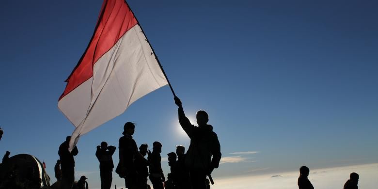 Pendaki mengibarkan bendera Indonesia di atas puncak Gunung Prau di saat hari kemerdekaan Indonesia.